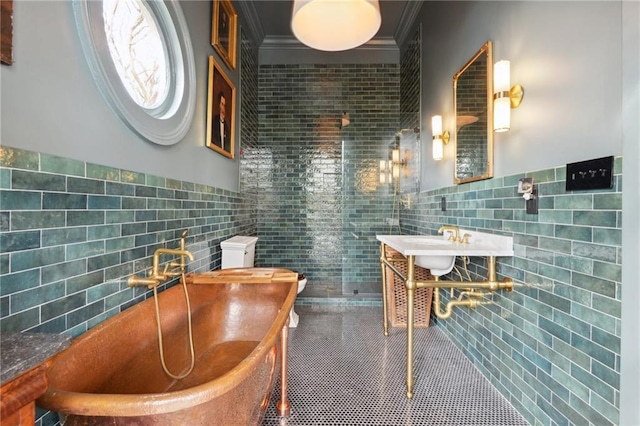 bathroom with tile walls, tile patterned flooring, crown molding, and a bath