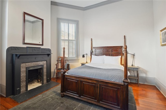 bedroom with dark hardwood / wood-style flooring and ornamental molding