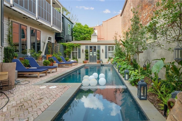 view of swimming pool with an outbuilding and a patio