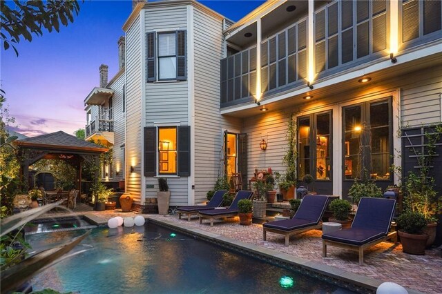 1013 Race St, New Orleans, LA 70130 - back house at dusk featuring a gazebo and a patio