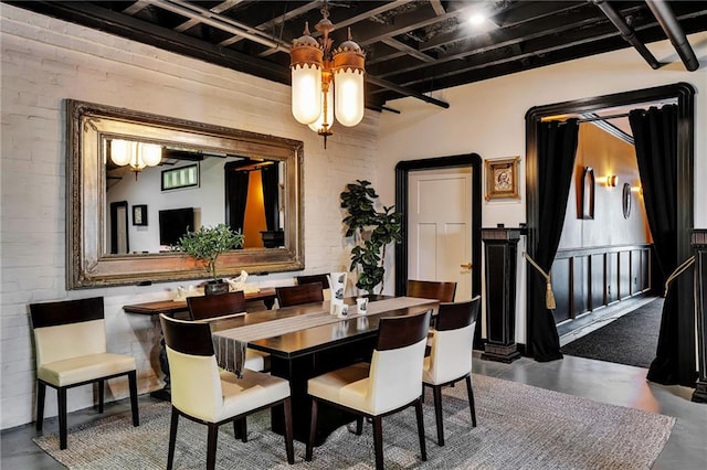 dining area with brick wall and concrete flooring