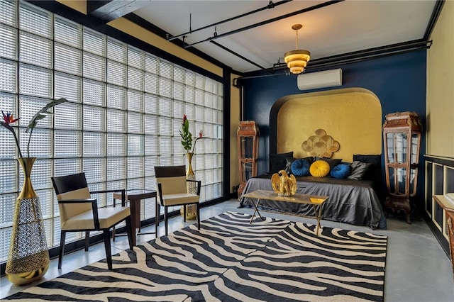 living area featuring plenty of natural light, concrete floors, and an AC wall unit