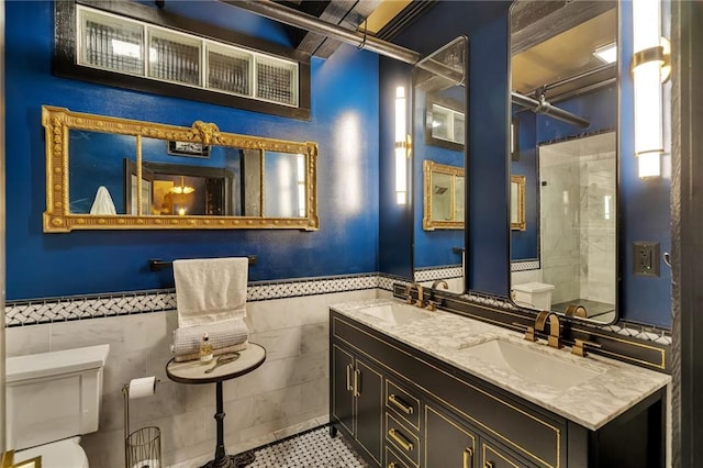 bathroom with vanity, tile walls, and toilet