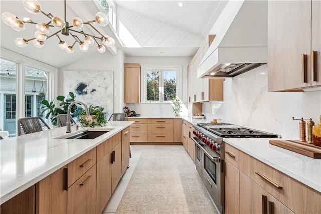 kitchen featuring range with two ovens, custom range hood, sink, and light brown cabinetry