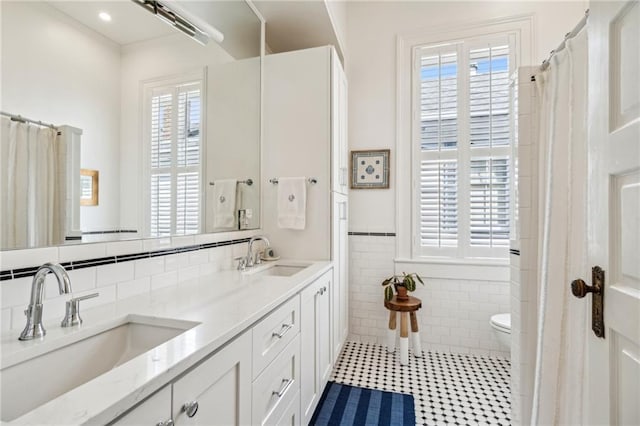 bathroom with a wealth of natural light, tile walls, and vanity