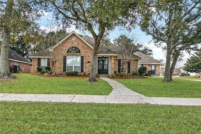 ranch-style home featuring central AC unit and a front yard