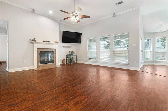 unfurnished living room featuring dark wood-type flooring, ornamental molding, a tile fireplace, and ceiling fan