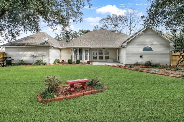 rear view of property featuring a patio and a yard