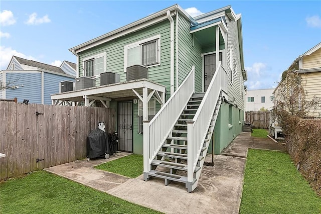 rear view of property featuring a yard and a patio area