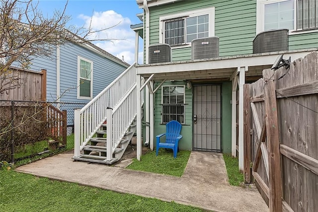 view of exterior entry featuring central AC unit and a patio area