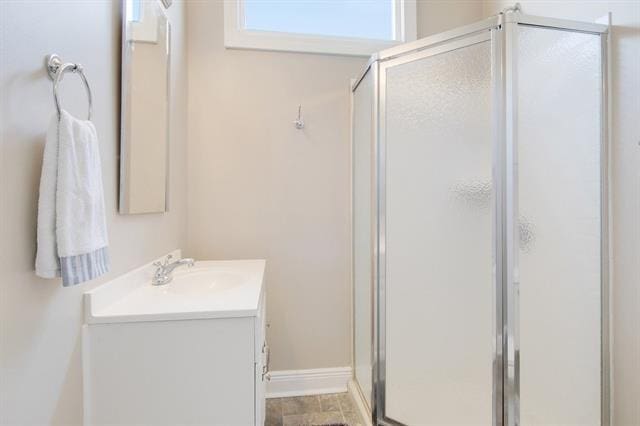 bathroom featuring vanity and a shower with door