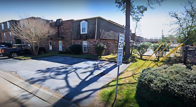 view of front of property featuring mansard roof and brick siding