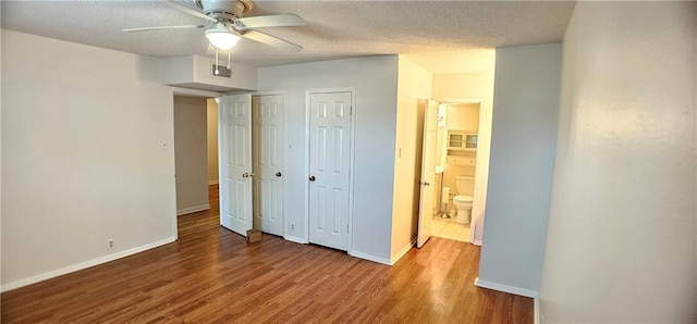 bedroom with visible vents, a ceiling fan, a textured ceiling, wood finished floors, and baseboards