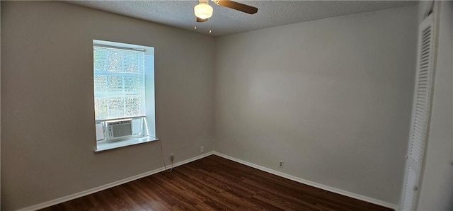 empty room featuring dark wood-type flooring, ceiling fan, a textured ceiling, cooling unit, and baseboards