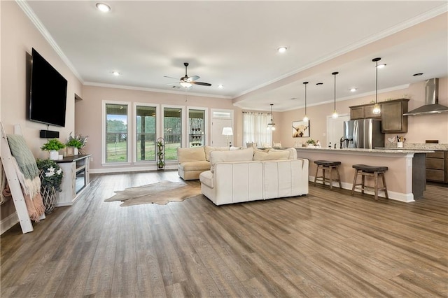 living room with ornamental molding, ceiling fan, and dark hardwood / wood-style flooring