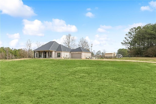 rear view of house with a garage and a lawn