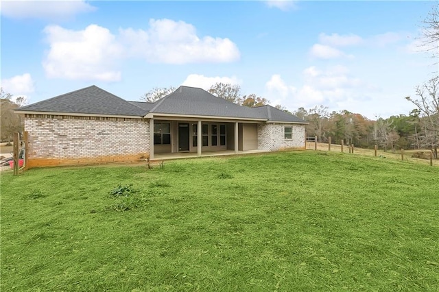 71078 Troy Spears Rd, Kentwood, LA 70444 - rear view of property featuring a patio, brick siding, roof with shingles, and a lawn