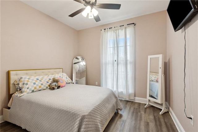 bedroom featuring ceiling fan, dark hardwood / wood-style floors, and multiple windows