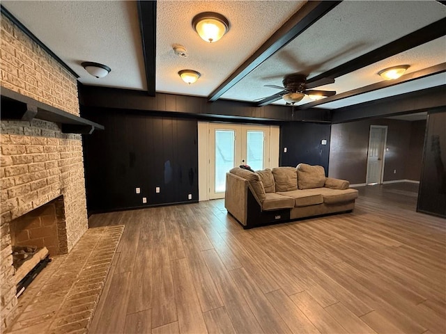 living room with hardwood / wood-style flooring, beam ceiling, and a textured ceiling