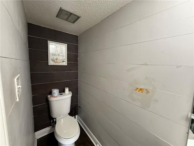 bathroom featuring a textured ceiling and toilet