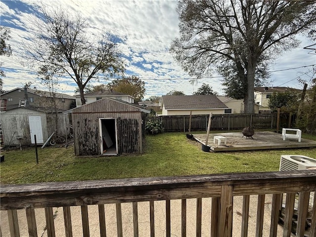 view of yard with a wooden deck, central air condition unit, and a storage shed