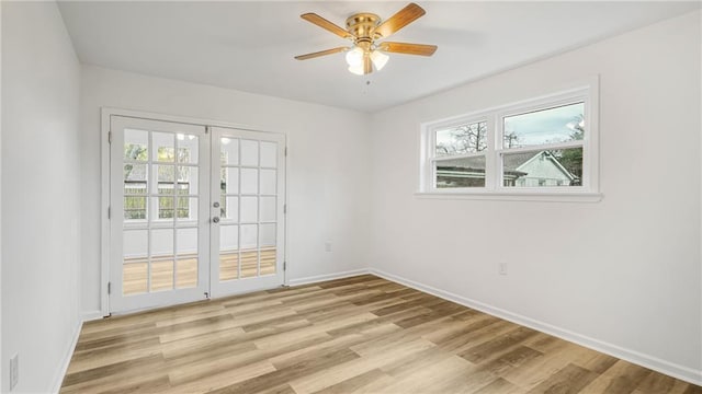 empty room with plenty of natural light, light hardwood / wood-style floors, french doors, and ceiling fan