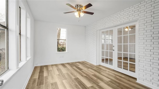 unfurnished sunroom with ceiling fan and french doors