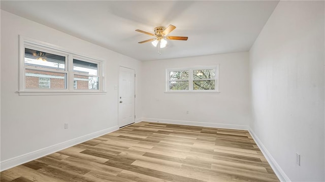 unfurnished room with a wealth of natural light, light hardwood / wood-style floors, and ceiling fan