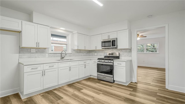 kitchen featuring white cabinetry, appliances with stainless steel finishes, sink, and light wood-type flooring