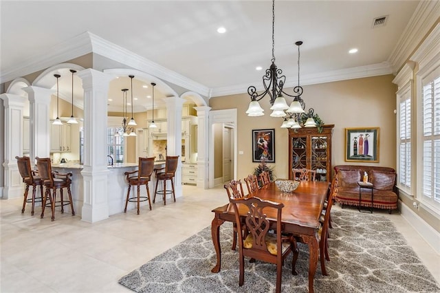 dining area with decorative columns, crown molding, and a healthy amount of sunlight