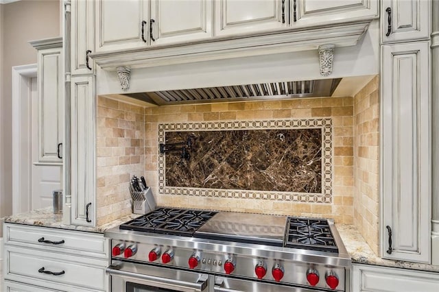 kitchen with white cabinetry, decorative backsplash, custom range hood, and range with two ovens