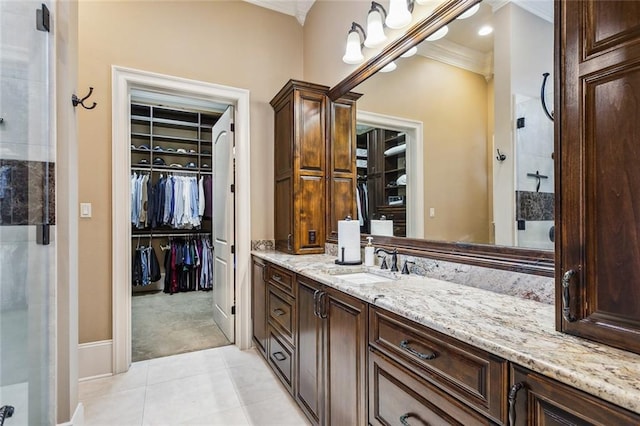 bathroom featuring vanity, tile patterned flooring, a shower with shower door, and ornamental molding