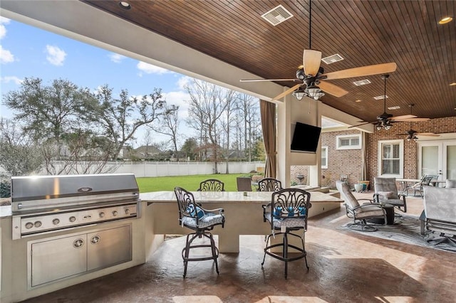 view of patio featuring ceiling fan, an outdoor kitchen, an outdoor bar, and area for grilling