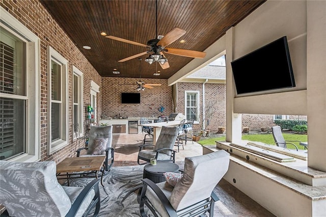 view of patio featuring exterior kitchen, an outdoor bar, and ceiling fan