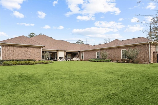 rear view of property featuring a lawn