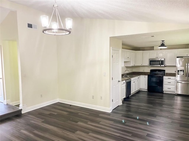 kitchen with lofted ceiling, sink, white cabinetry, decorative light fixtures, and stainless steel appliances