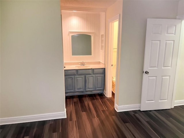 corridor with sink and dark wood-type flooring