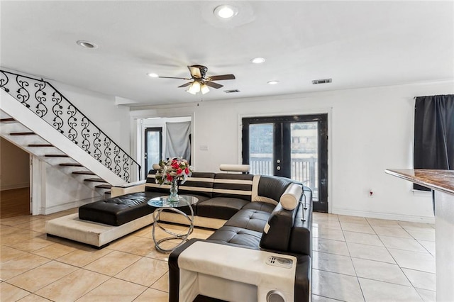 tiled living room with french doors and ceiling fan