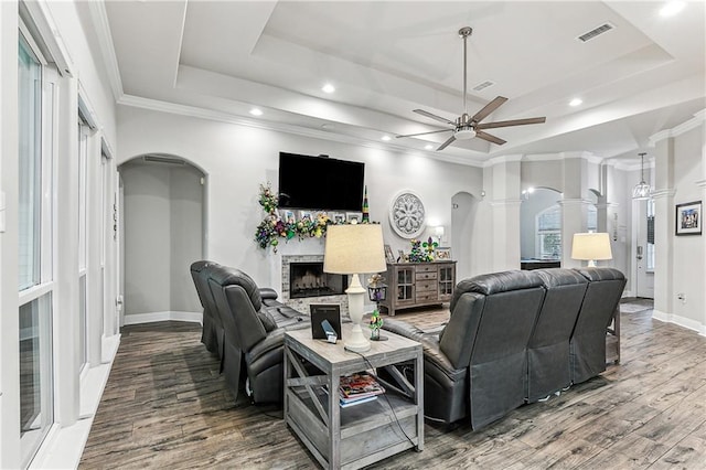 living room featuring crown molding, a tray ceiling, ceiling fan, and hardwood / wood-style flooring