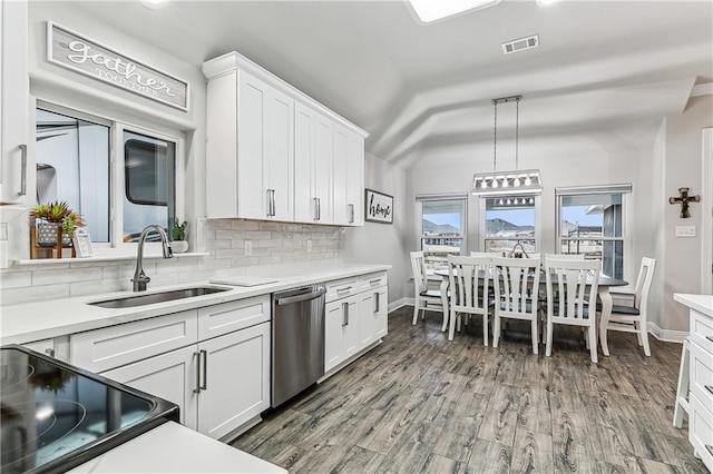 kitchen featuring white cabinetry, sink, decorative light fixtures, and stainless steel dishwasher