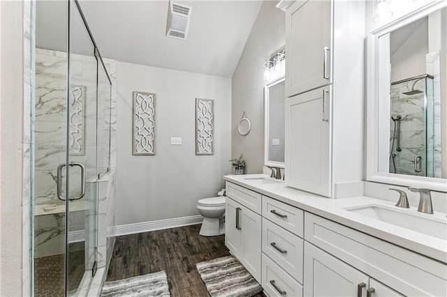 bathroom with toilet, vaulted ceiling, vanity, a shower with door, and hardwood / wood-style flooring