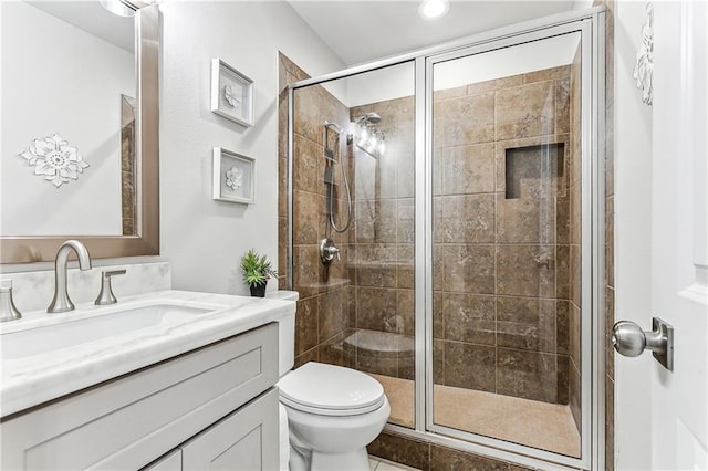 bathroom with walk in shower, vanity, and toilet