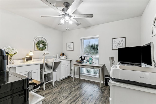 office space with built in desk, dark wood-type flooring, and ceiling fan