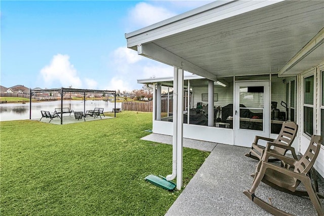 view of yard with a water view, a sunroom, and a patio