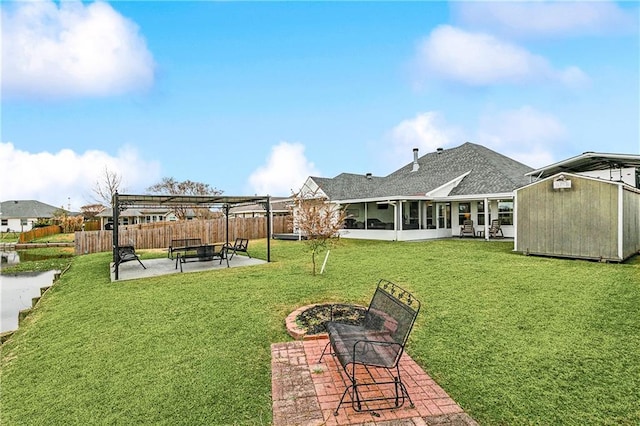 view of yard with a storage shed, a pergola, a sunroom, and a patio