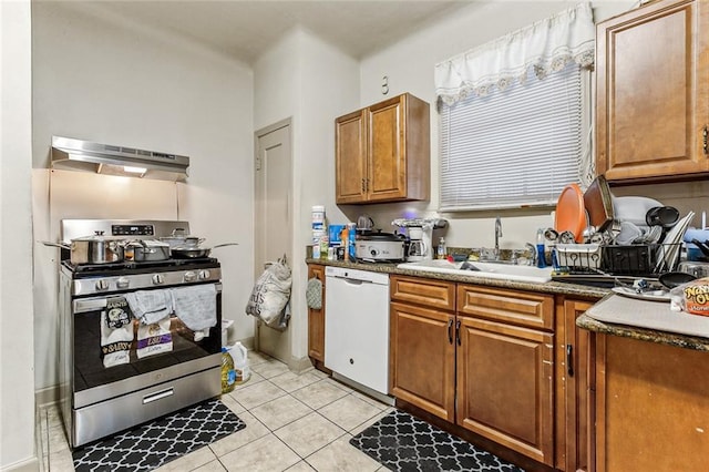 kitchen with white dishwasher, sink, light tile patterned floors, and gas stove