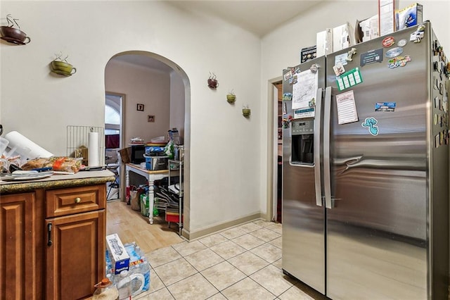 kitchen with light tile patterned flooring and stainless steel fridge