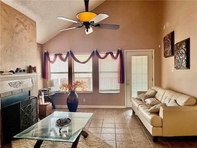 living room with a tile fireplace, high vaulted ceiling, a textured ceiling, and ceiling fan