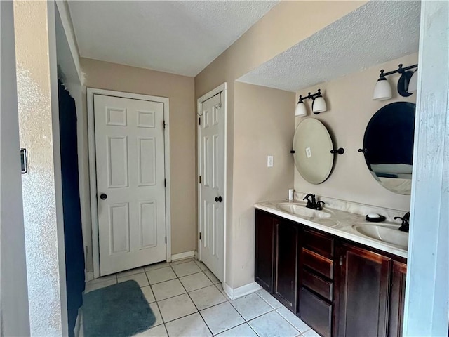 bathroom featuring tile patterned floors, vanity, and a textured ceiling