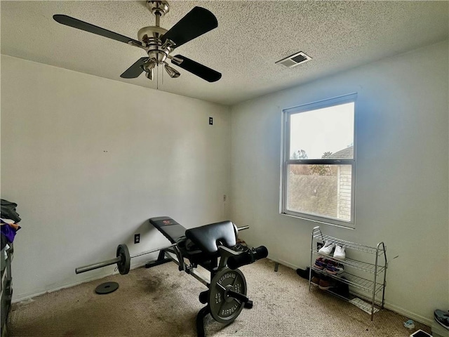 workout room with ceiling fan, a textured ceiling, and carpet flooring